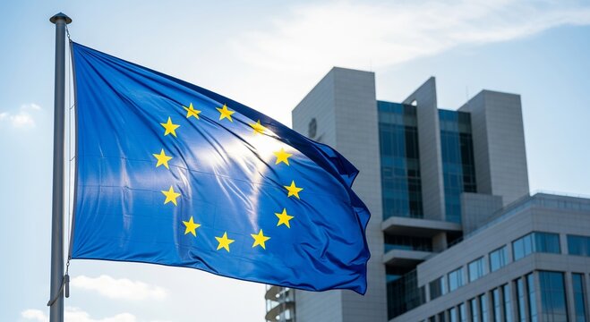European union flag waving near modern city building with blue sky
