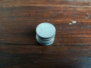 Five hundred rupiah coins on wooden background