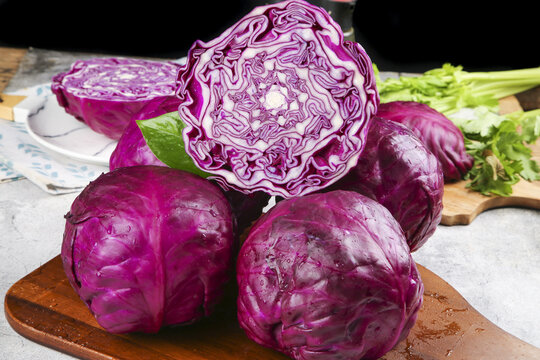 Fresh Purple Cabbage and Green Leafy Vegetables on Wooden Cutting Board for Healthy Nutrition Cooking
