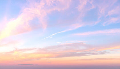 Soft and dreamy pastel sky at sunset with gentle clouds in shades of pink, blue, and yellow.