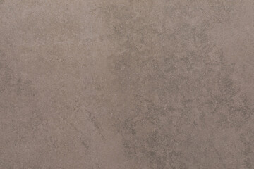 Textured surface with earthy tones showing natural variations in color and pattern under soft light during the day
