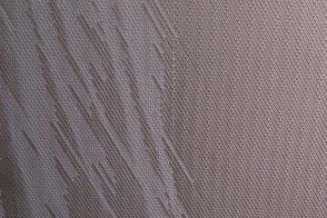 Close-up view of textured fabric showing subtle variations in color and pattern during daylight