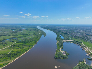 Obraz premium A wide aerial perspective showing the Oka River curving through the green landscape with the cityscape of Murom visible on the right bank.