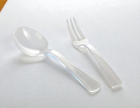 Clear plastic spoon and fork on white surface