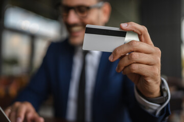 Businessman making online payment using credit card and laptop