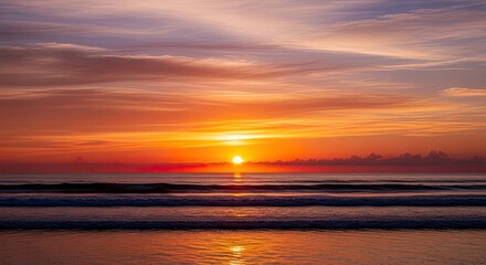 Breathtaking vibrant sunset over the tranquil ocean waves on a serene beach, casting warm reflections.