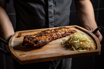 Grilled pork ribs with cabbage salad on wooden board