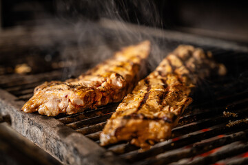 Pork ribs cooking on grill with smoke