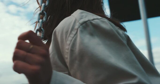 Beautiful young girl swinging on a swing front to back