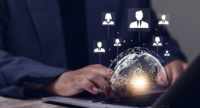 Businessman using laptop to manage global network hologram, person, symbolizing modern business concepts such as human resources (HR), recruitment and international team management.