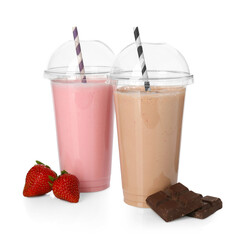 Milkshakes of different flavors in plastic cups and ingredients isolated on white