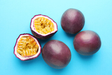 Fresh passion fruits on light blue background. Whole and cut