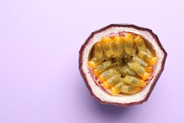 Half of fresh passion fruit on violet background, closeup. Space for text