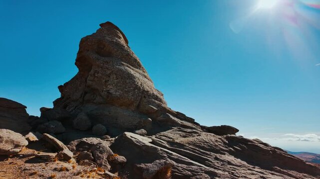 Mushroom shaped and anthropomorphic rock formations in a beautiful mountain range, displaying weathered stone columns, rounded caps, and curious silhouettes, under open sky across rugged terrain