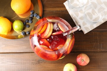 Tasty punch and fruits on wooden table, flat lay. Refreshing drink