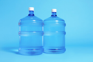 Cooler bottles with water on light blue background