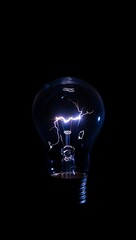 Illuminated light bulb with electrical sparks isolated on black background studio shot
