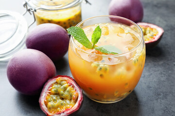 Tasty passion fruit drink with mint and fresh fruits on grey table, closeup