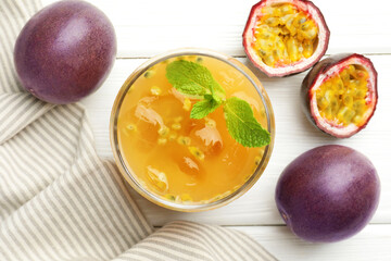 Tasty passion fruit drink with mint and fresh fruits on white wooden table, flat lay