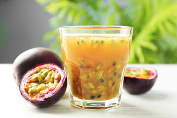 Tasty passion fruit drink and fresh fruits on white wooden table, closeup