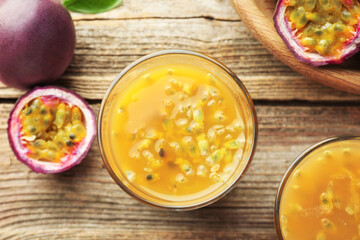 Tasty passion fruit drink and fresh fruits on wooden table, flat lay