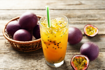 Tasty passion fruit drink and fresh fruits on wooden table, closeup