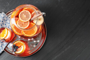 Fruity punch on black table, top view with space for text. Refreshing drink