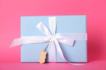 Gift box with blank tag on pink background