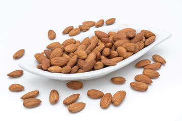 Roasted almonds on white plate isolated.	