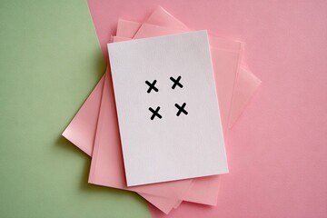 Minimalist White Card with Four Black Cross Marks on Pastel Background.