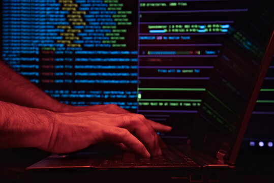 Man working with an AI chat bot online and hacking a system. IT engineer, software developer, and programmer interact with the chat bot, writing code. Hacker and system invasion.