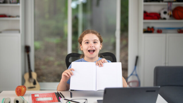 Kid studying at home with laptop and books. Child study online using laptop at desk. Studying with homework in child room. E-studying on laptop. Kid studying at home. Interior with kid and laptop. - Powered by Adobe