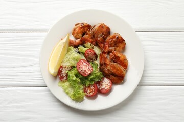 Tasty grilled shrimps with salad on white wooden table, top view. Delicious seafood dish