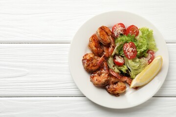 Tasty grilled shrimps with salad on white wooden table, top view with space for text. Delicious seafood dish