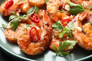 Tasty grilled shrimps with herbs and spices on black table, closeup. Delicious seafood dish