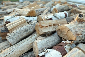 Pile of cut firewood outdoors, closeup view