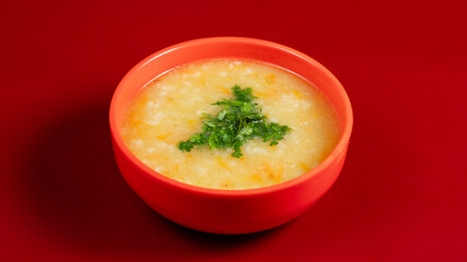 Chicken soup bowl on red background