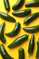 Green jalapeno peppers on yellow background, flat lay