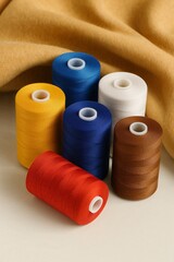 Colorful spools of sewing thread in studio style, red blue yellow white brown colors, textile crafts and tailoring concept, Sewing Machine Day
