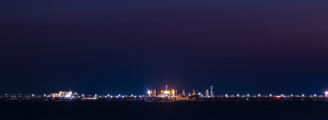 Fototapeta premium night scene of Oil ship tanker ship load or unload oil at loading dock from refinery for transportation on the sea