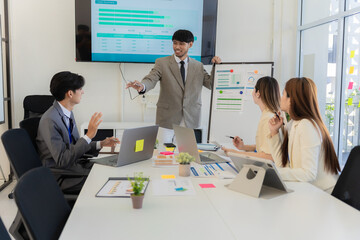 Marketing concept with laptop in office, Asian business group teamwork brainstorming meeting and discussing strategy, financial analysis, successful plan.