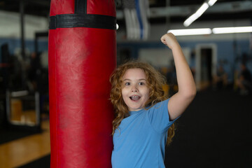 Child boxing. Kid boxer boxing in gym. Child wearing boxing gloves. Boy practicing martial arts....
