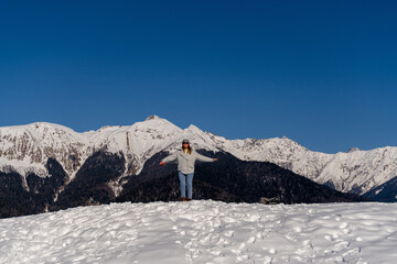 Mountains Snow Woman Winter: Joyful pose, snowy mountain range, sunny day, celebrating nature.