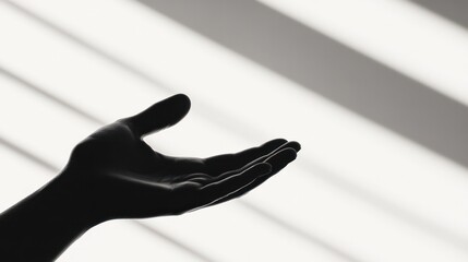 Reaching Out: A monochrome image captures a silhouette of a hand, outstretched, bathed in the dramatic interplay of light and shadow, evoking a sense of hope, anticipation, and connection.