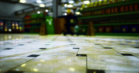 Obraz premium The picture shows a tiled floor viewed from a low angle, leading to a grocery store. Colorful shelves stacked with products line the background, creating a lively atmosphere.