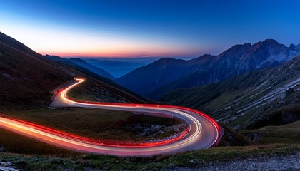 spiral road winding through night mountains with red and blue light trails