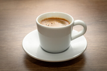 Freshly brewed Turkish coffee in cup on wooden table