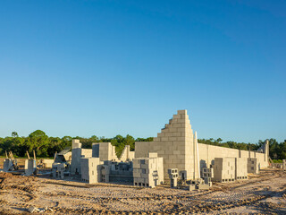 Corner of a single-family house under construction early in masonry stage in a suburban residential...