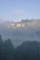 fog in the mountains houses at altitude green forest summer