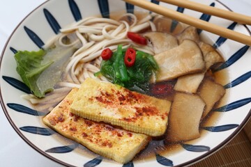 Tasty ramen with king oyster (eryngii) mushrooms in bowl on table, closeup
